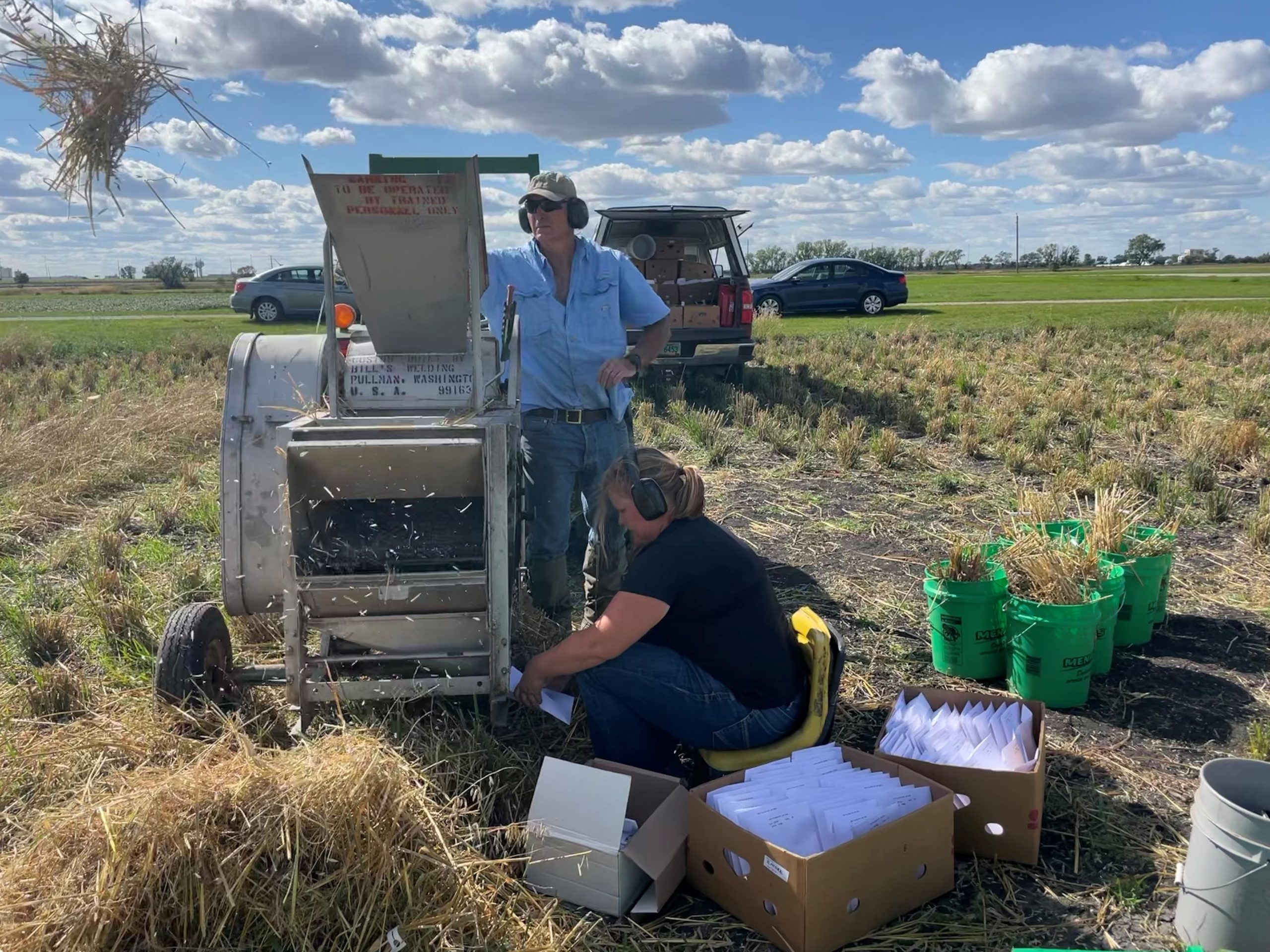 2 oat researchers gather data in the field.